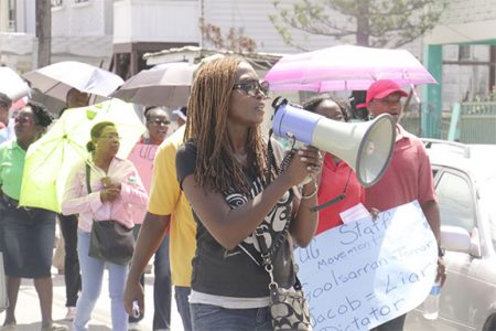 Dr Mellissa Ifill leading the chant during yesterday’s march to the city by striking university workers.
