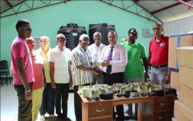 Food for the Poor Guyana Inc CEO Kent Vincent (at right) during the handing over of sunglasses to President of the Society for the Blind Cecil Morris.  