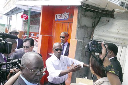 Donald Rodney (second from left) stands in front of the White Castle Fish shop, the exact location where his car was parked on the night of the explosion.
