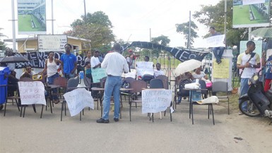 Students protesting in front of the main gate of the University of Guyana Turkeyen Campus. 