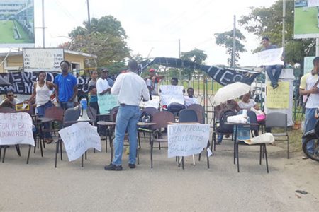 Students protesting in front of the main gate of the University of Guyana Turkeyen Campus. 