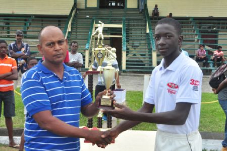 Player of the match Garfield Benjamin accepts his MVP trophy from Selector Nazimul Drepaul. (Orlando Charles photo)