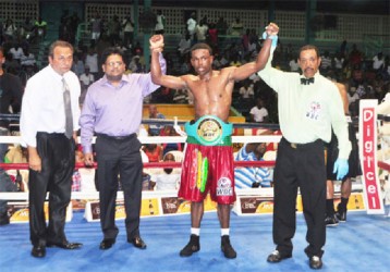 Minister of Finance, Ashni Singh and referee Eon Jardine raises the hand of the newly crowned WBC CABOFE light welterweight champion, Clive Atwell as president of the GBBC, Peter Abdool looks on. (Orlando Charles photo) 