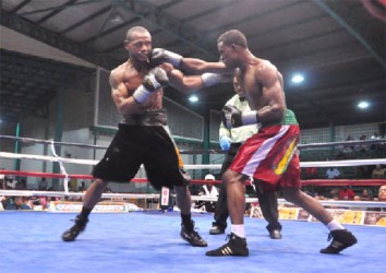  Clive ‘The Punisher’ Atwell (right) lands a right hand to the jaw of Sakima Mullings during part of their action packed bout on Saturday night at the Cliff Anderson Sports Hall. (Orlando Charles photo) 