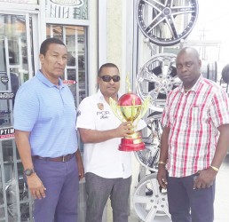 Auto Fashion Proprietor Noel Shewjattan (centre) displaying the most valuable player (MVP) trophy while being flanked by Co-Directors Aubrey Major (right) and Kashif Mohammed during the brief handing over ceremony. 
