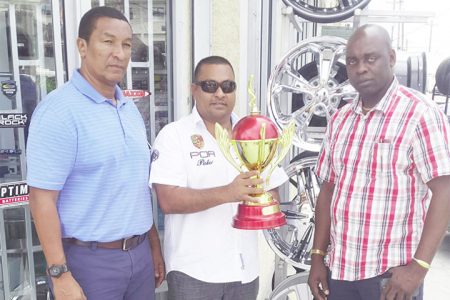 Auto Fashion Proprietor Noel Shewjattan (centre) displaying the most valuable player (MVP) trophy while being flanked by Co-Directors Aubrey Major (right) and Kashif Mohammed during the brief handing over ceremony.
