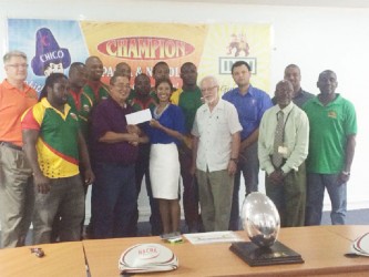 Executive of Edward B. Beharry and Companies, Anjuli Beharry-Strand (centre) presenting the sponsorship cheque to president of the GRFU Peter Green in the presence of players and the union’s executives.   
