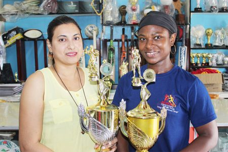 Devi Sunich (left) of the Trophy Stall presents the winning male and female trophies to Noshavyah King, the coordinator of the inaugural E-Networks Crossfit Games.