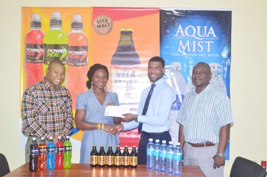 Aqua Mist Brand Manager Errol Nelson, presents a cheque to coordinator of the Games, Noshavyah King of Genesis Fitness Express while Troy Peters, Communications Manager of the local beverage giant and brand manager, Colin King look on. 