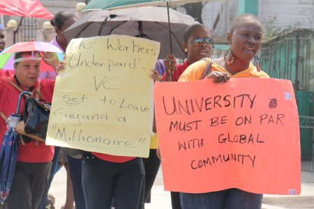 Two UG workers expressing their thoughts on placards yesterday during their protests at various points in the city.