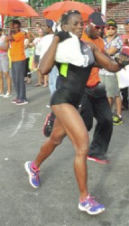 Alisha Fortune of Team GDF running with a sand bag during yesterday’s grueling test of fitness. (Orlando Charles photo)