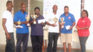 Mashramani draughts champion Khemraj Pooranmall, second right displays the first place trophy. Others in picture are from left, Esan Anderson, Mark Brathwaite, Jairam, Steve Bacchus and Marlyn Ali. 