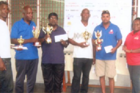 Mashramani draughts champion Khemraj Pooranmall, second right displays the first place trophy. Others in picture are from left, Esan Anderson, Mark Brathwaite, Jairam, Steve Bacchus and Marlyn Ali.
