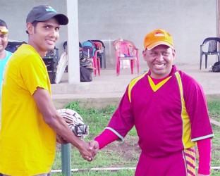 Proprietor of Tiger Sports and former national wicketkeeper/batsman, Sheik Mohamed (right), presents a pair of batting glove to Guyana Media XI opener, Ravi Persaud. 