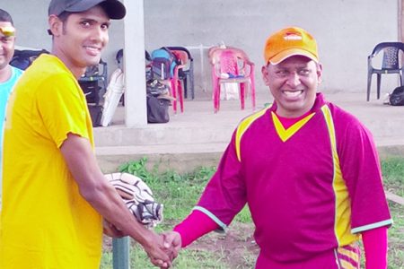 Proprietor of Tiger Sports and former national wicketkeeper/batsman, Sheik Mohamed (right), presents a pair of batting glove to Guyana Media XI opener, Ravi Persaud.

