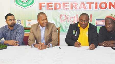 Jamaal Shabazz (3rd from left) in the process of inking his two year contract with the GFF Normalization Committee while Normalization Committee member Tariq Williams (left), Chairman Clinton Urling (2nd left) and Assistant coach Wayne Dover look on
