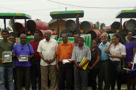 Minster Norman Whittaker stands with the overseers and chairpersons in front of the new tractors and trailers