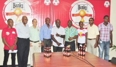 President of the GRFU, Peter Green (left) is all smiles yesterday as he received the sponsorship cheque from Banks DIH’s Communications Manager, Troy Peters in the presence of the union’s top brass. (Orlando Charles photo) 