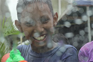 This young boy had fun spraying cars as they passed through a street in Kitty.  