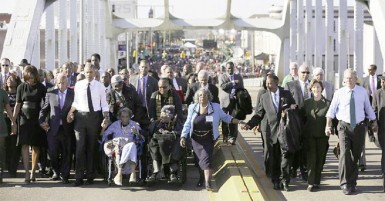 US President Barack Obama (3rd L) participates in a march across the Edmund Pettus Bridge in Selma, Alabama, March 7, 2015. Also pictured are first lady Michelle Obama (L), US Representative John Lewis (D-GA) (2nd L), former first lady Laura Bush (2nd R) and former president George W Bush (R). (Reuters/Jonathan Ernst)