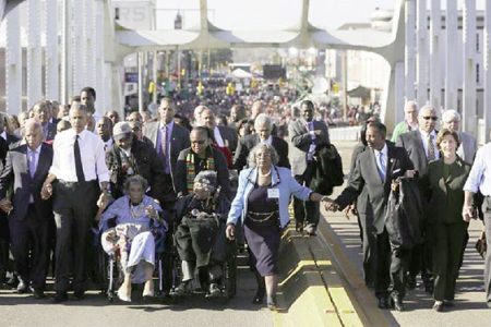 US President Barack Obama (3rd L) participates in a march across the Edmund Pettus Bridge in Selma, Alabama, March 7, 2015. Also pictured are first lady Michelle Obama (L), US Representative John Lewis (D-GA) (2nd L), former first lady Laura Bush (2nd R) and former president George W Bush (R). (Reuters/Jonathan Ernst)