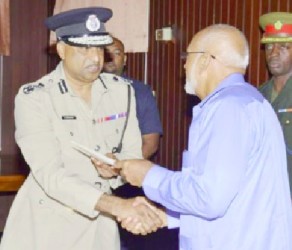 Police Commissioner Seelall Persaud (left) receiving his instrument of appointment from President Donald Ramotar. (GINA photo) 