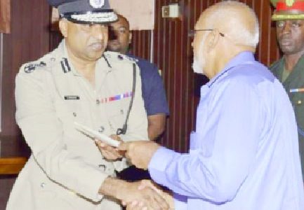Police Commissioner Seelall Persaud (left) receiving his instrument of appointment from President Donald Ramotar. (GINA photo)
