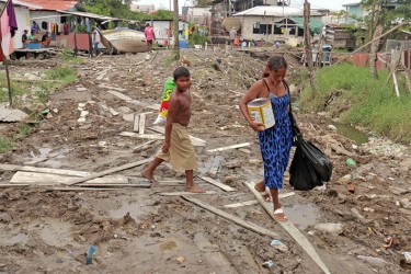 These Ruimveldt residents have to walk through slush and garbage to get home. 