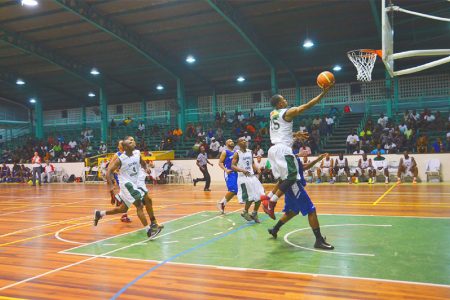 Guyana’s Shelroy Thomas (#15) in the process of scoring a lay-up while being challenged by John Lee of Bermuda during his side’s historic victory
