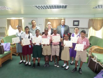 The winning children with (from right in back row) Speaker, Raphael Trotman, UNICEF Representative Marianne Flach and artist, Philbert Gajadhar.  