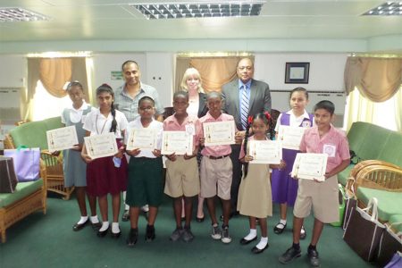 The winning children with (from right in back row) Speaker, Raphael Trotman, UNICEF Representative Marianne Flach and artist, Philbert Gajadhar.