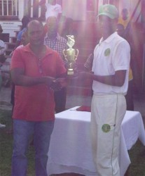 Demerara skipper Ronaldo Ali-Mohamed receives the winning trophy from chairman of the junior selection panel Sauid Drepaul. 