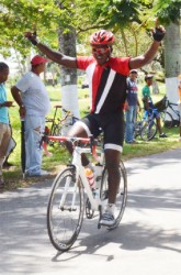 Trojan Cycle Club’s Jeban Crawford crosses the finish line unchallenged to take the spoils of the 10th annual Diamond Mineral Water criterium programme yesterday at the National Park. 