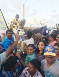 Handlers of Score’s Even celebrate with the winner’s trophy following the memorable victory yesterday at the Kennard’s Memorial Turf Club.  