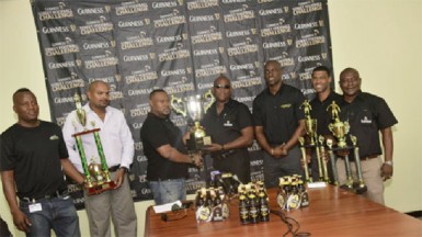 Tournament Coordinator Troy Mendonca (third from left) receiving the championship trophy from Banks DIH East Coast Area Manager Clive Pellew while other members of the launch party inclusive of Guinness Brand Manager Lee Baptiste (third from right) looks on.