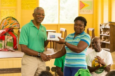 David Granger presenting the tablet to Claudia Monah-Morris 