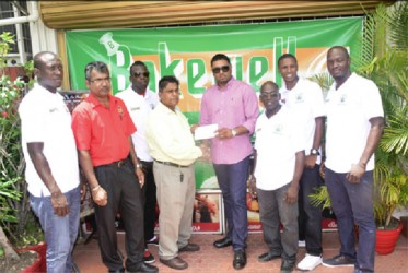 Slingerz FC owner and President Javed Ali (fourth from right) receiving the sponsorship cheque from Bakewell General Manager Rajin Ganga while other members of the club look on.