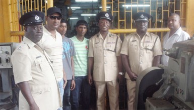 The students posing with the owner of the workshop, Nandkumar Brijlall (second, left) and the officers from right to left; Assistant Superintendent of Police, Ramesh Singh, Deputy Commander, Stephen Mansel, Commander, Marlon Chapman and senior officer, Clayburn Johnson  