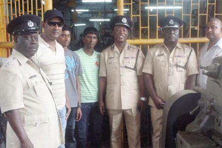 The students posing with the owner of the workshop, Nandkumar Brijlall (second, left) and the officers from right to left; Assistant Superintendent of Police, Ramesh Singh, Deputy Commander, Stephen Mansel, Commander, Marlon Chapman and senior officer, Clayburn Johnson 