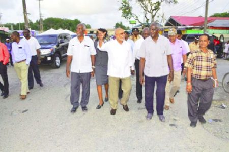 President Donald Ramotar (second from left) and officials walking along the roadway after the ceremony yesterday to start the Vreed-en-Hoop to Parika Road Project. (GINA photo)