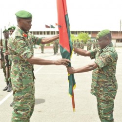 Col Wilbert Lee (left) officially hands over the Unit Colours to Lt Col Terry Benn on Thursday during his farewell parade at Hard Square, Camp Stephenson. (Guyana Defence Force photo)