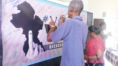 People signing the ‘Vote Like A Boss’ banner yesterday at the Guyana National Youth Council launch of the voters education campaign.