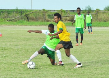 Keith Caines of Chase Academy (right) on the attack while being pursued by his Queenstown Secondary marker during his side’s quarterfinal victory 