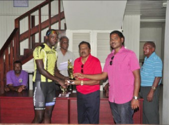 Akeem Arthur out pedaled a field of Guyana’s premier cyclists to win the third and final leg of the Cheddi Jagan Memorial road race series yesterday in Essequibo, but Hamza Eastman’s consistency enabled him to lift the overall trophy of this year’s event. By virtue of winning the first leg, placing fifth in the second leg and finishing second yesterday, the Team Coco’s standout was crowned this year’s champion. In yesterday’s 55-mile trek, which pedaled off from Supenaam, proceeded to Charity and ended at Anna Regina, Arthur (2hr:07m:09s)  led Eastman and last year’s overall winner, Alanzo Greaves onto the podium. Veteran rider, Robin Persaud and United Bike Shop’s Horrace Burrows were fourth and fifth respectively while Team Alanis’ Paul Choo-Wee-Nam placed sixth. Yesterday’s race commenced as cool as the weather in the Cinderella County and there was not much theatrics on the upward journey. When the wheelsmen turned back at Charity, the peloton was still mostly together save for a few stragglers and Orville Hinds who unfortunately suffered an early puncture.  There were several mini breaks on the way back to Anna Regina but the attackers were quickly wheeled in by the peloton.   The cyclists pretty much stuck to the script until Arthur solo attacked in the final 300m and held on for his first win of the season.  His attack went unchallenged as Eastman, the virtual leader heading into yesterday’s leg was content on preserving his one point lead ahead of Greaves.  Eastman’s tactic did not prove costly as he was able to edge out Greaves on the line in the bunch sprint.  Marica Dick (female), Julio Melville (Mountain Bike), Andrew Hicks (Junior) and Ralph Williams (veteran) were also categorical winners yesterday. Notes: The sum of 38 riders started in yesterday’s race. The Memorial event is in it’s 18th year. It is held to commemorate the life and works of former president, Cheddi Jagan. Jagan would have celebrated his 92nd birth anniversary yesterday. The initial leg was staged on the roadways of West Demerara while the second leg was held in Berbice. Yesterday’s event was sponsored by S.Jagmohan Hardware Supplies and Constructing Services for the eighth consecutive year. (Emmerson Campbell)   