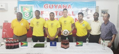 Newly recruited Golden Jaguars Neil Danns (3rd from left) and Matthew Briggs (4th from left) posing for a photo opportunity with members of the national team staff and Banks DIH Limited inclusive of head-coach Jamaal Shabazz (left) during their presentation to the media 