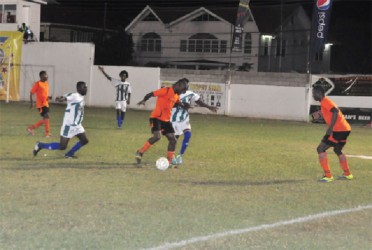 Midfielder Clive Nobrega (centre) of Slingerz FC trying to maintain possession of the ball while being challenged by a Victoria Kings player during their matchup at the DCC ground 