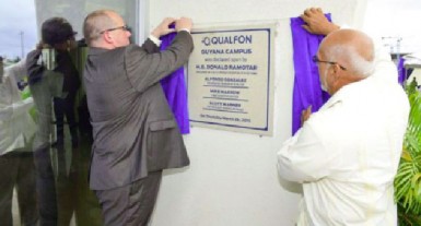 President Donald Ramotar (right) and a Qualfon official unveiling the plaque to the Qualfon campus at Providence yesterday. (GINA photo) 