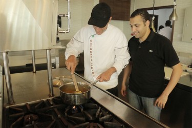 A chef from the Renaissance in Sao Paulo, Brazil working with staff in the open concept kitchen of the primary dining area of the hotel.