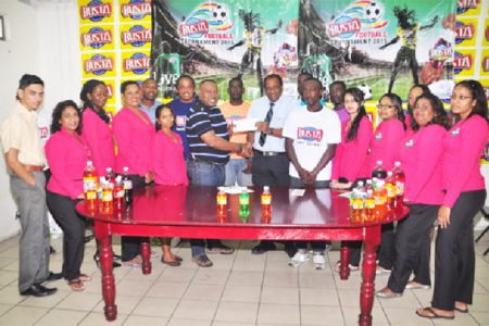  Tournament Coordinator Troy Mendonca (centre) receiving the championship trophy from Guyana Beverage Company Managing Director Robert Selman while members of the company and several representatives of the competing teams look on.
 
