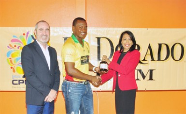 Jamie Stewart (left) watches on as Amazon Warrior’s Chris Barnwell receives a bottle of 21 year-old rum from DDL’s Marketing Director Sharda Vereen-Chand.